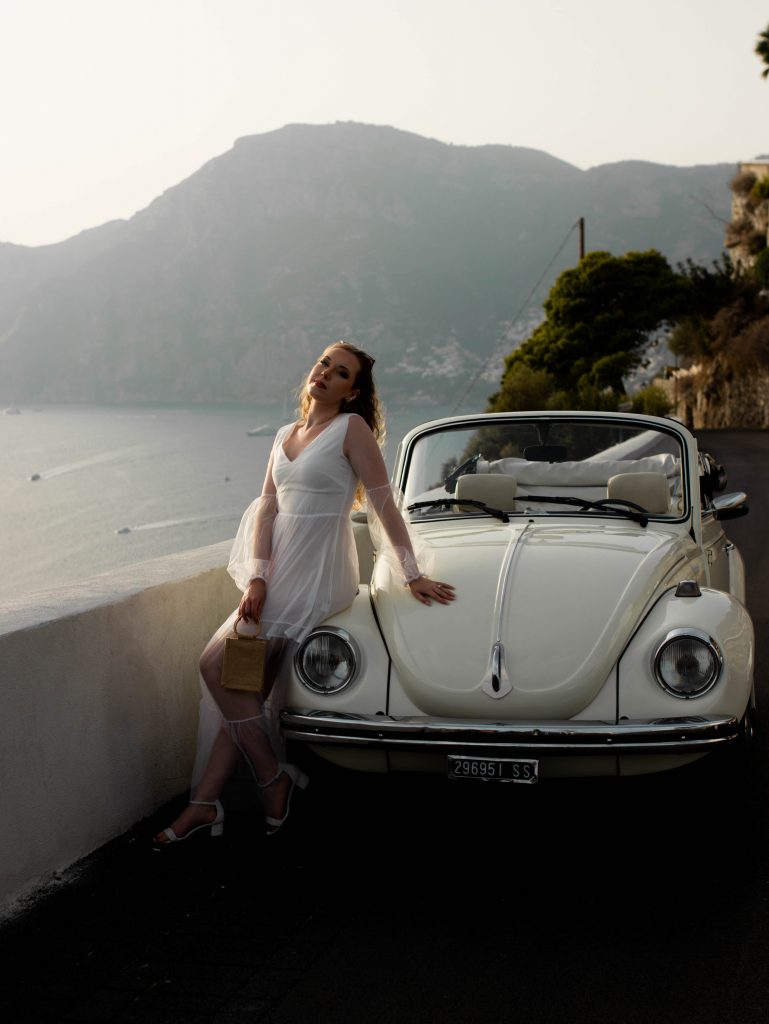 Leaning against a vintage car in Positano, Italy